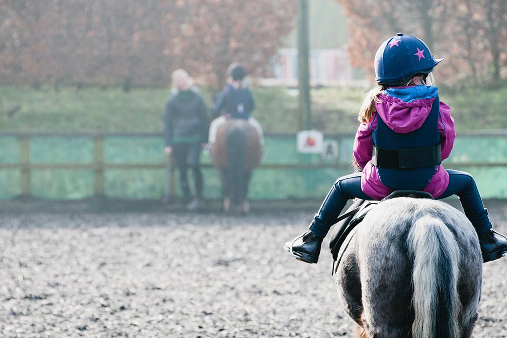 Child riding a pony at West Sussex equestrian centre
