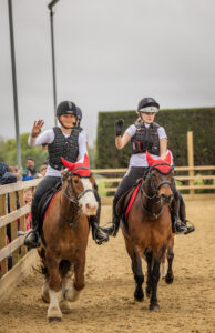 Children learning to ride ponies