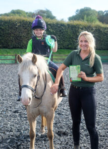 Coach with member achieving certificate and rosette